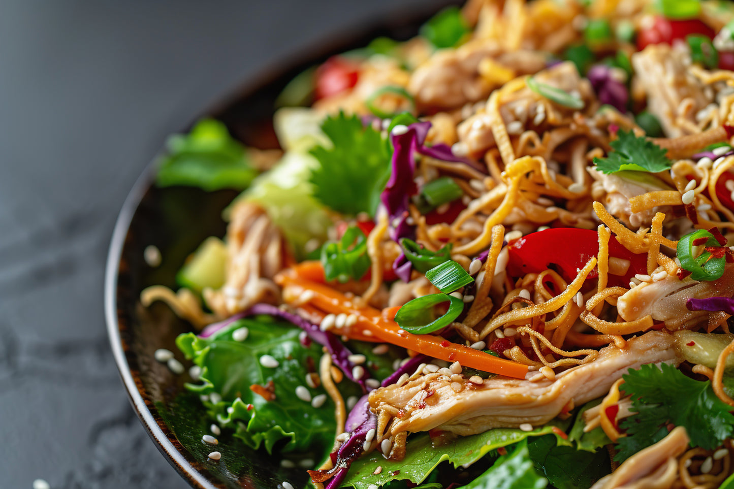 High-Protein Asian Chicken Salad with grilled chicken breast, napa cabbage, purple cabbage, carrots, edamame, cilantro, and homemade sesame dressing.